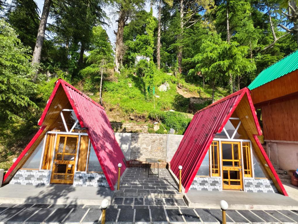 a building with red roofs and stairs with trees at Eva Cabins in Dalhousie