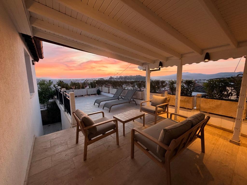 a patio with chairs and a sunset in the background at Sunset House in Selçuk