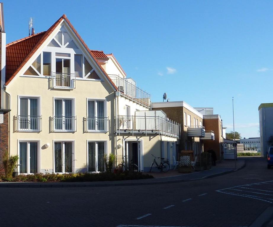 ノルダーナイにあるSonneneckの通り側のバルコニー付き白い建物