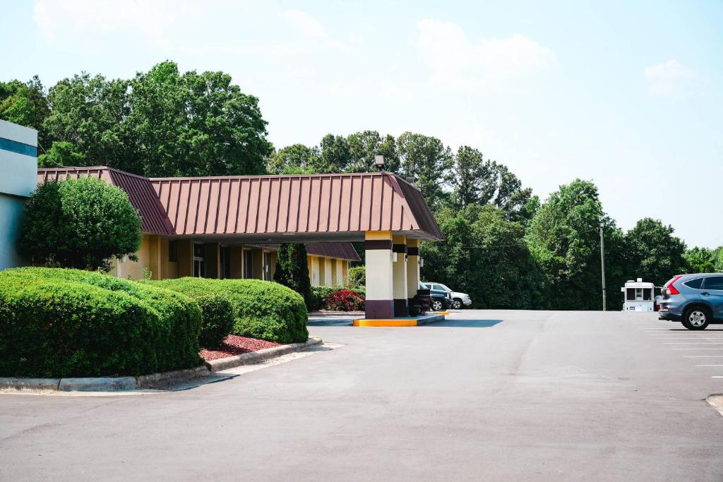 a building with a car parked in a parking lot at Rodeway Inn Monroe in Monroe