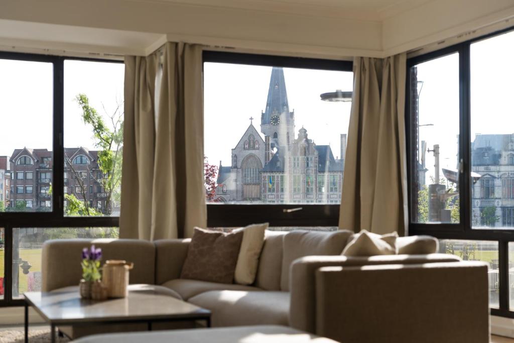 a living room with a couch and large windows at Spacious Apartment at Top Location Grote Markt in Sint-Niklaas