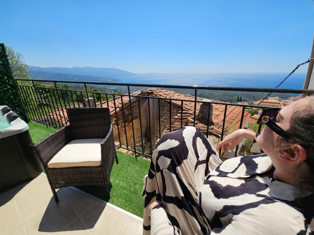 a woman sitting in a chair on a balcony at Casa Nevina in Marathokampos