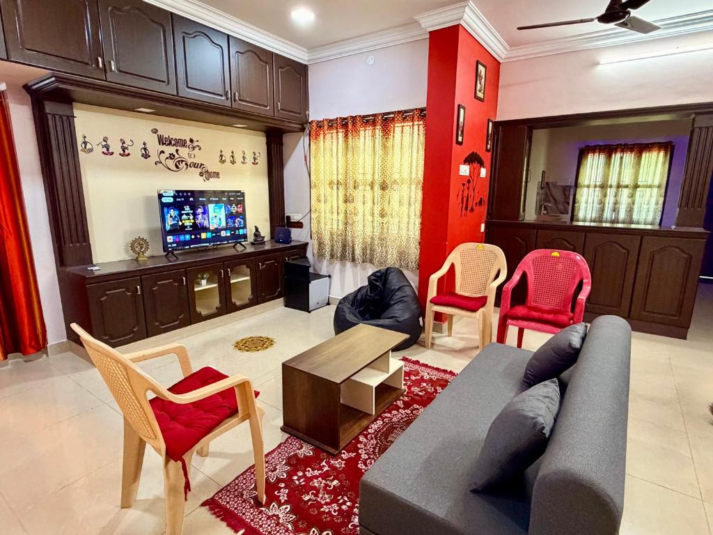 a living room with a couch and chairs and a tv at Royal Paradise Inn in Chidambaram