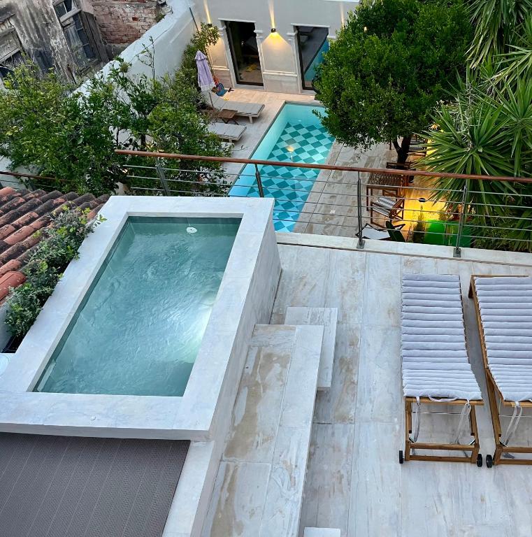 a swimming pool with two lounge chairs and a swimming pool at Thirty8 Heritage House in Chania