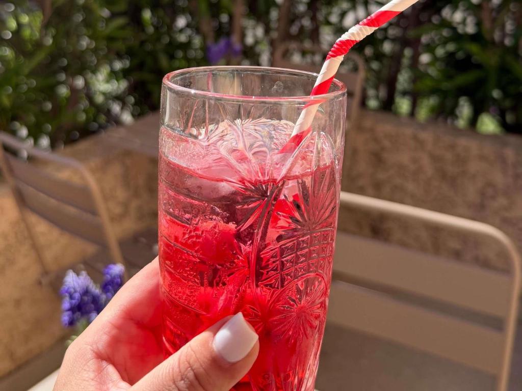 a person holding a red drink with a straw at ibis budget Marseille Aeroport Provence in Marignane
