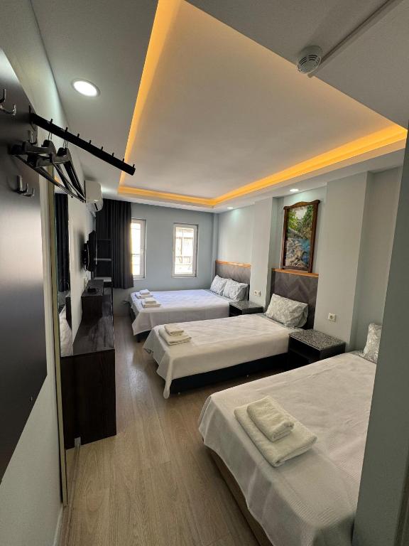 a room with three beds and a living room at Kışla Pansiyon in Antalya