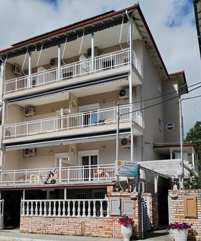 a building with a balcony on the side of it at Achilleas Apartments in Paralía Skotínis