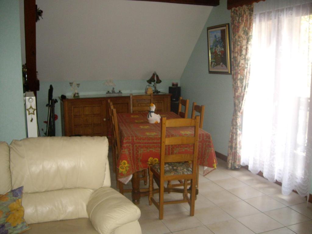 ein Wohnzimmer mit einem Tisch und einem weißen Sofa in der Unterkunft appartement vue sur la montagne in Soultzeren