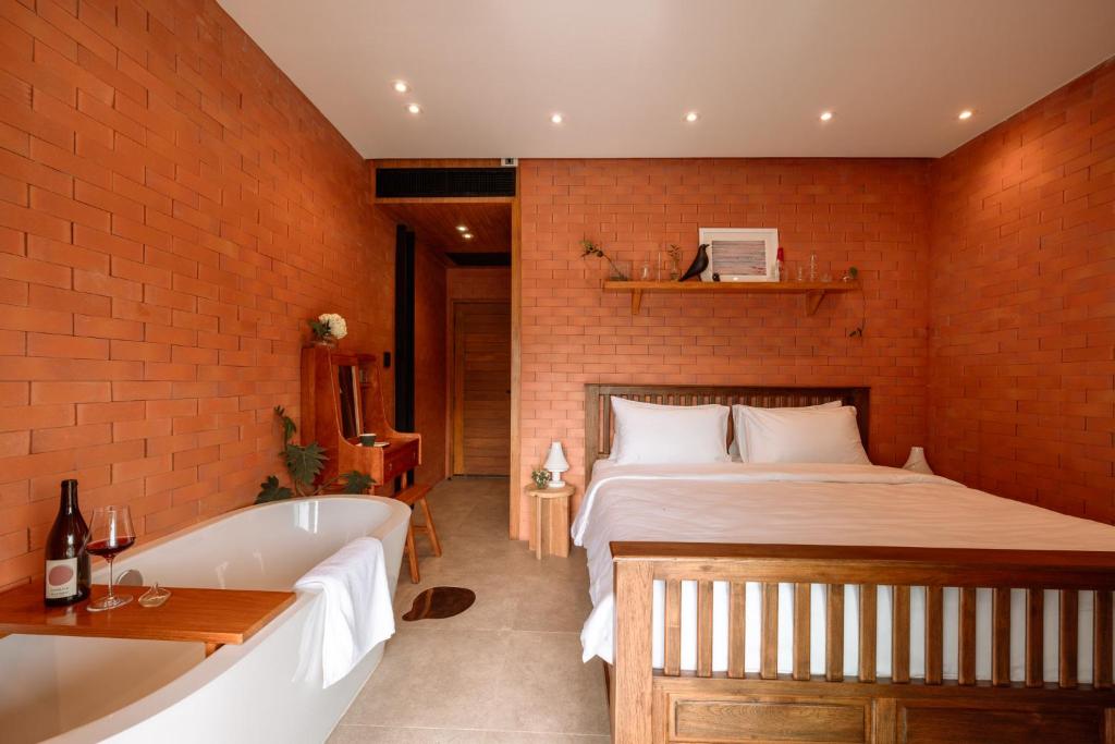 ein Schlafzimmer mit einem großen Bett und einer Badewanne in der Unterkunft Easterly Room 02 in Chanthaburi
