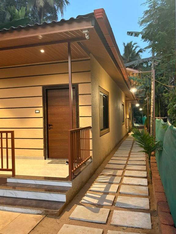 a house with a wooden door and a porch at Seven Seas Beach Resort in Diveagar