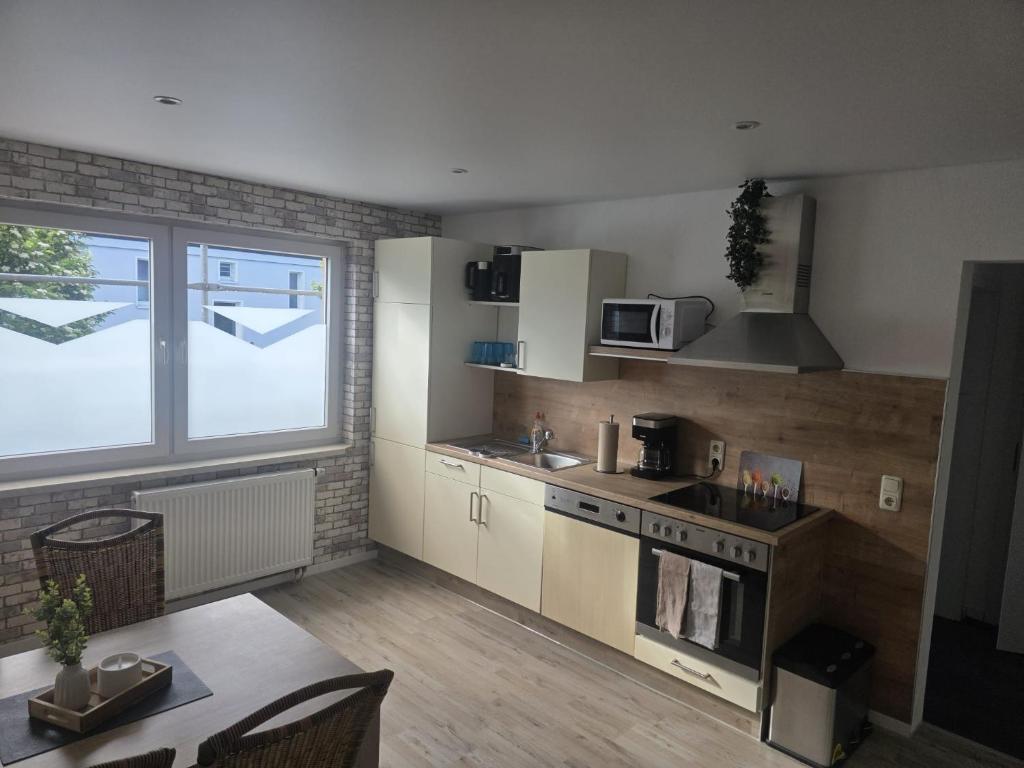 a kitchen with a stove and a table and a window at Ferienhaus Anna in Übach-Palenberg