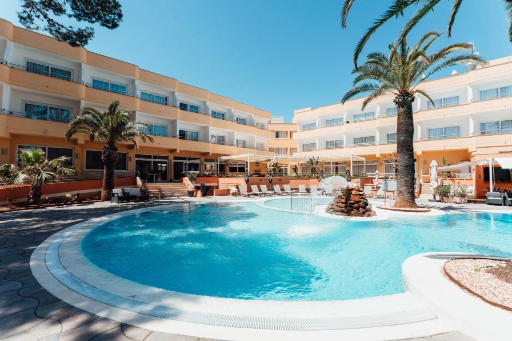a large swimming pool in front of a hotel at Sagitario Playa in Cala Blanca