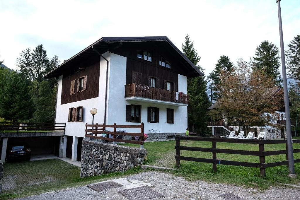 une maison avec un balcon et une clôture devant elle dans l'établissement Casa Pineta, à Ledro