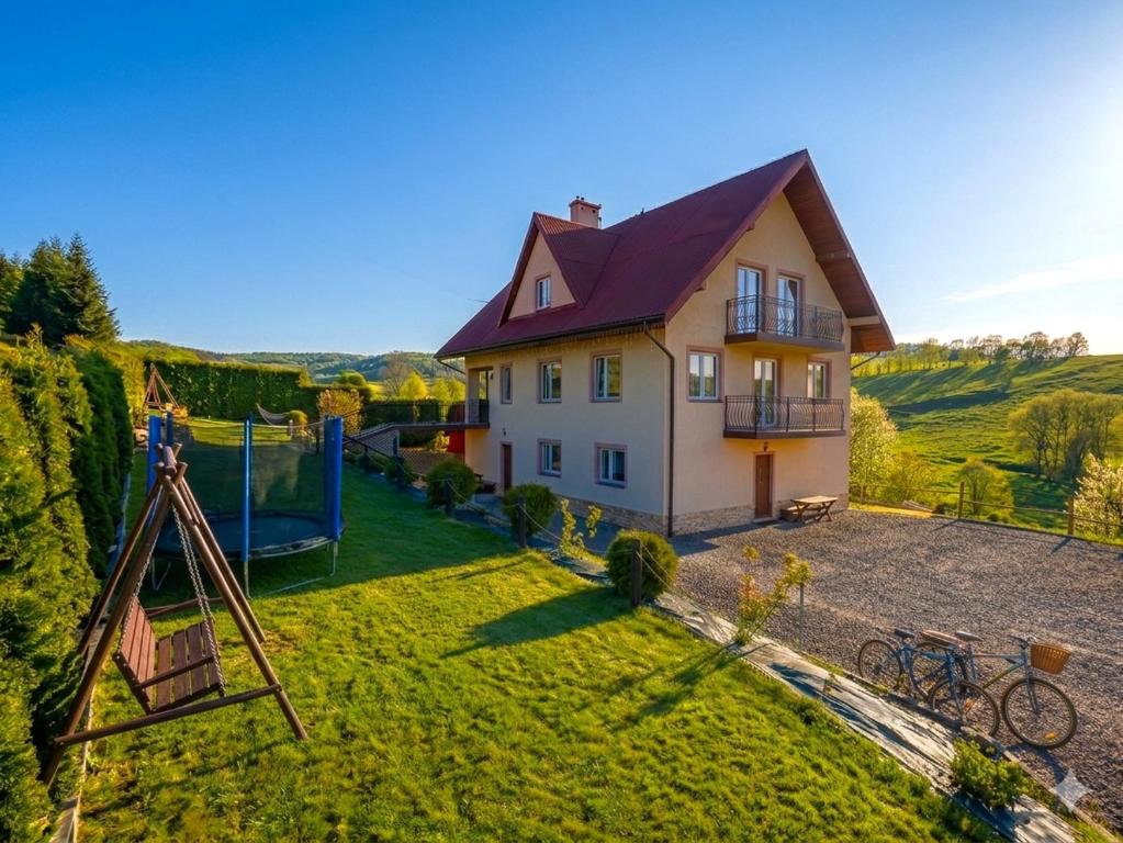 an aerial view of a house with a playground at Cichy Potok in Polańczyk