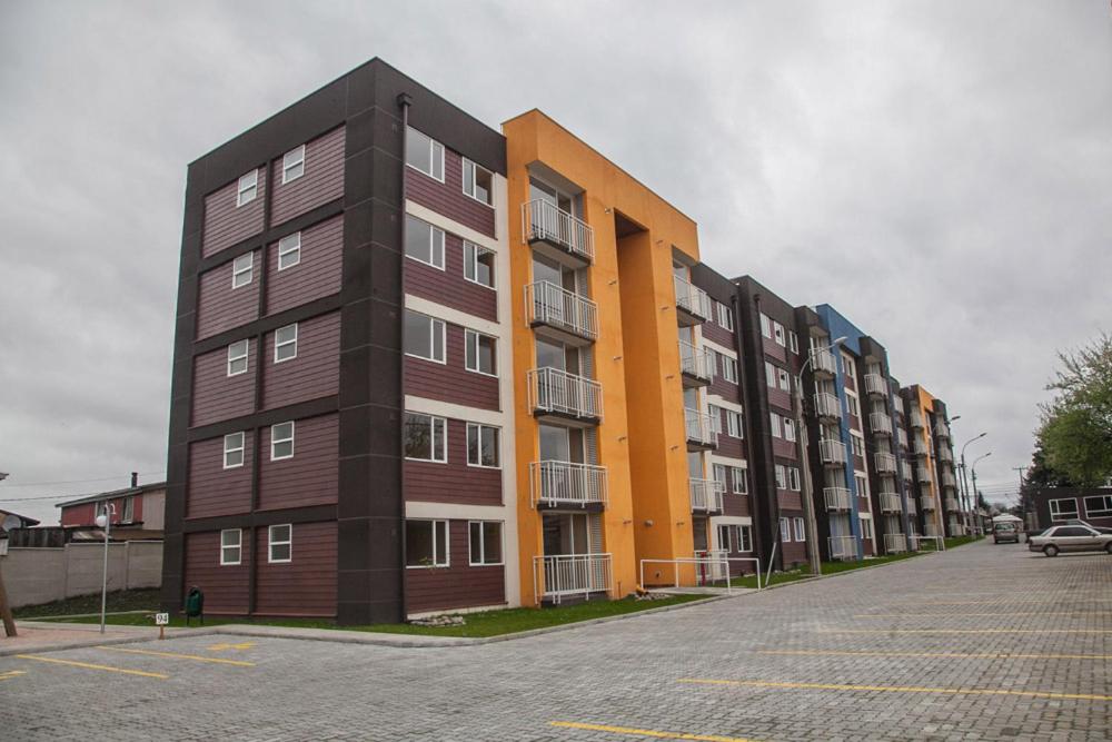 una fila de edificios de apartamentos en un estacionamiento en Condominio Matta Torre 1, en Temuco