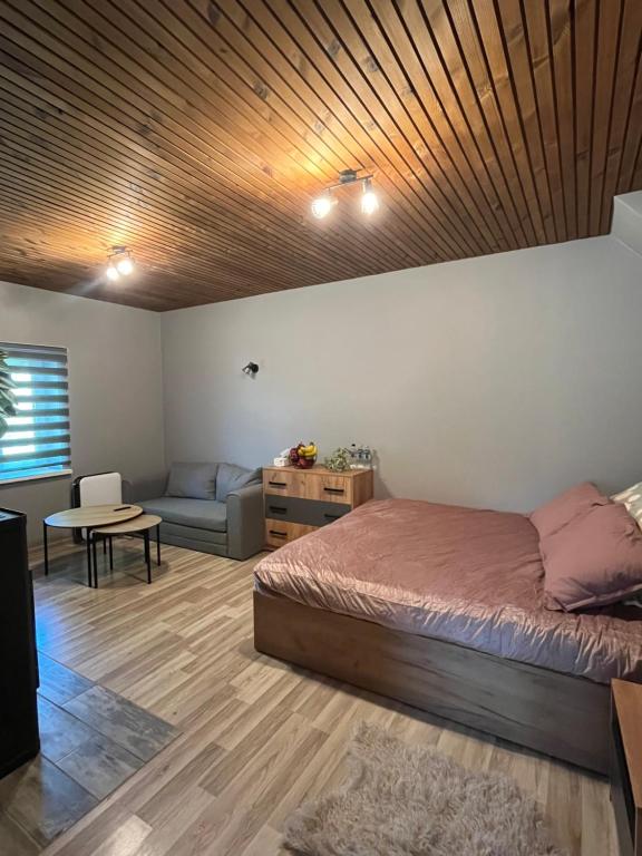 a bedroom with a bed and a couch and a table at Pavasari in Cēsis