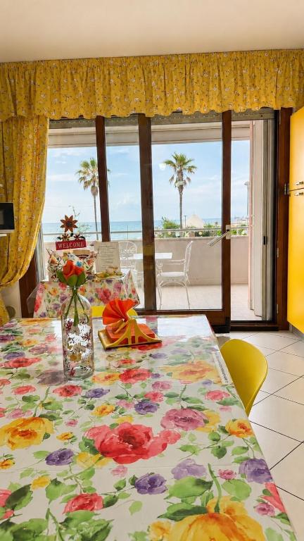 a table with a floral table cloth on it with a view of the ocean at Sea Colors Apartment in Montesilvano