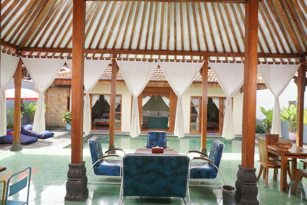 a dining room with a table and chairs in a pavilion at Villa Joglo Kawung - City Centre Paradise with Pool in Yogyakarta