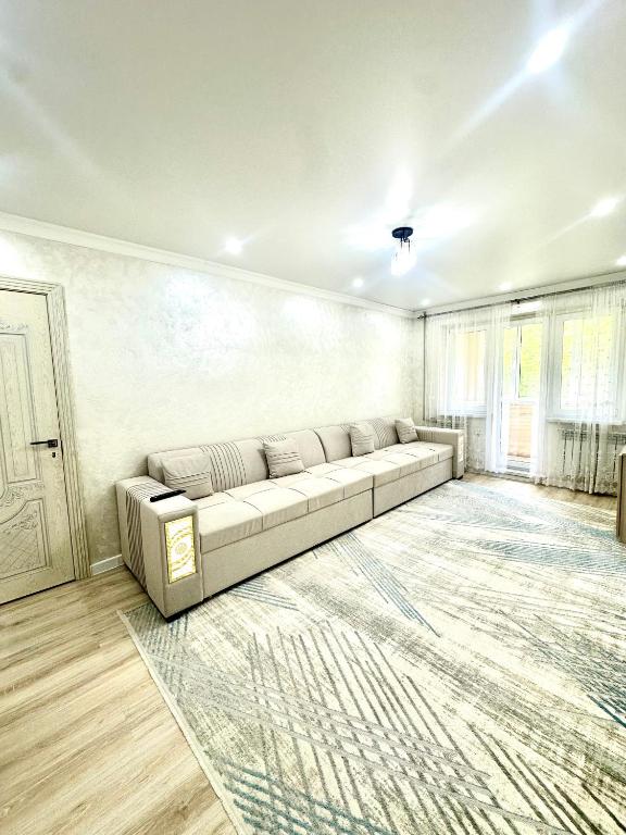a living room with a couch and a rug at Apartment Plaza tower in Shymkent