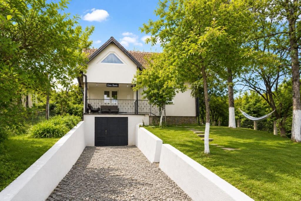 a white house with a gate and a yard at Casa Bando in Moacşa