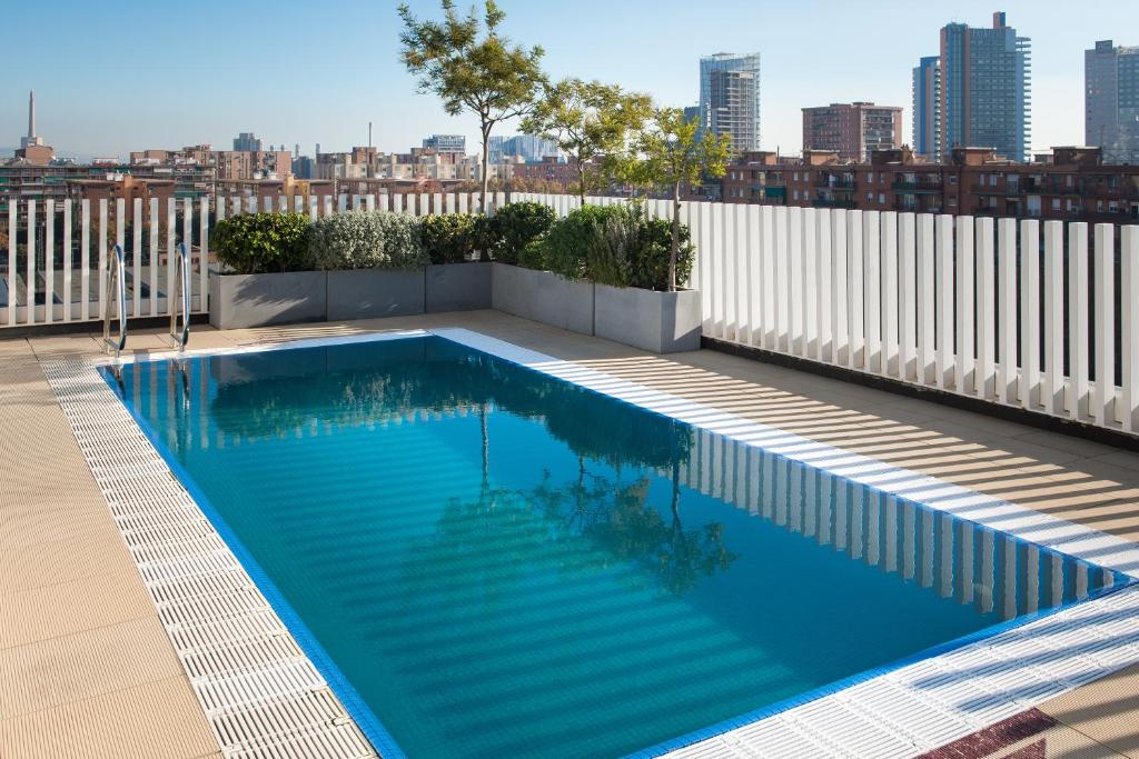 a large swimming pool with a balcony overlooking a city at Vincci Bit in Barcelona