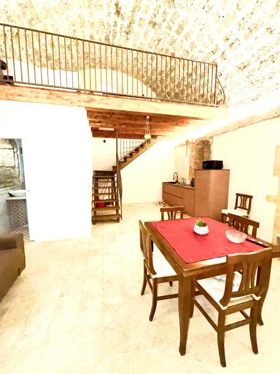 a room with a table and chairs and a staircase at Nonna Pia in Noto