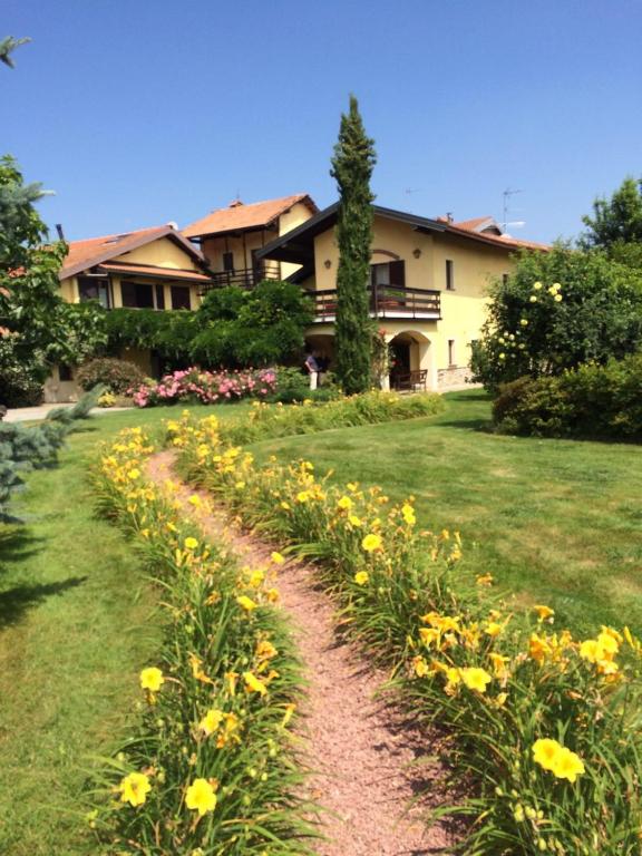 a garden with yellow flowers in front of a house at Relais Dei Cesari in Borgo Ticino