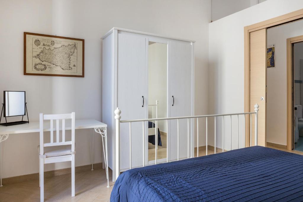 カターニアにあるAppartamenti Francescoのベッドルーム1室(ベッド1台、デスク、椅子付)