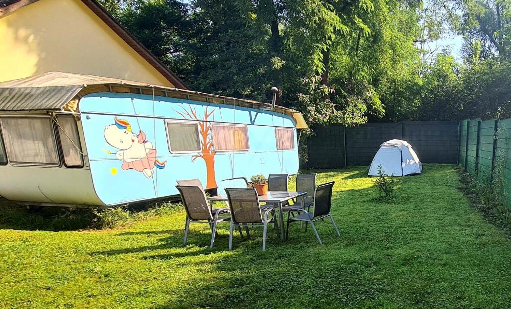 a table and chairs in front of a trailer at Quiet caravan in nature on Mur cycle path in Feldkirchen bei Graz