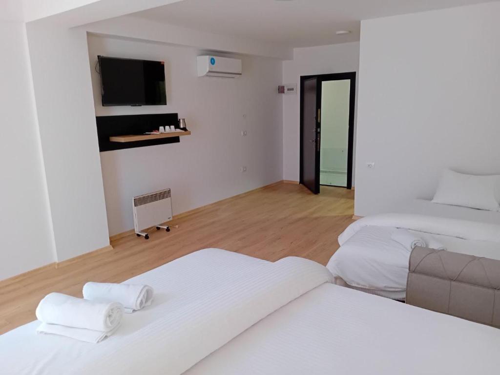 a white room with two beds and a television at Venecia gold in Struga