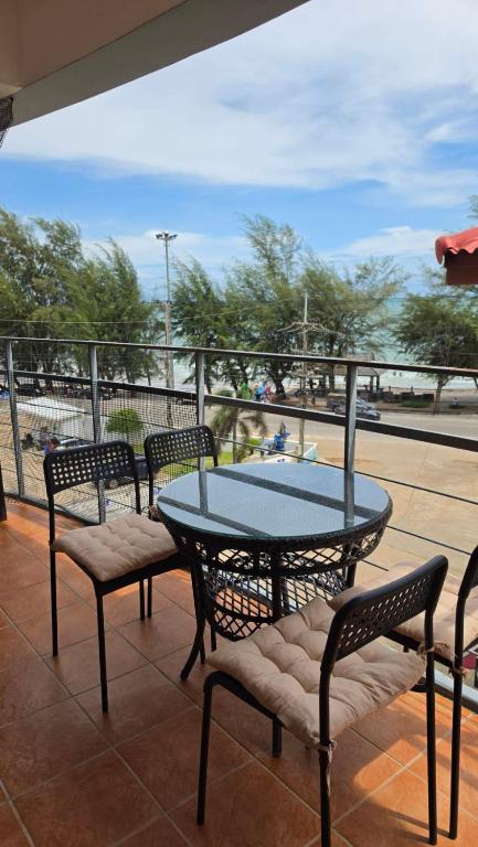 a table and chairs on a patio with a view of the ocean at Avatara A condominium C41 with sea view in Ban Tha Fat