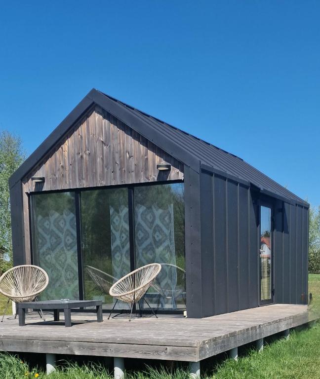 a black house with two chairs and a table at Forest edge in Saugos
