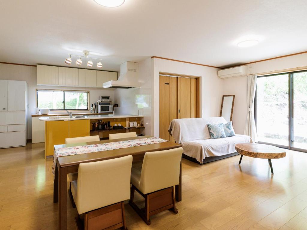 a kitchen and living room with a table and a bed at Holiday Home 郷 in Minami Aso