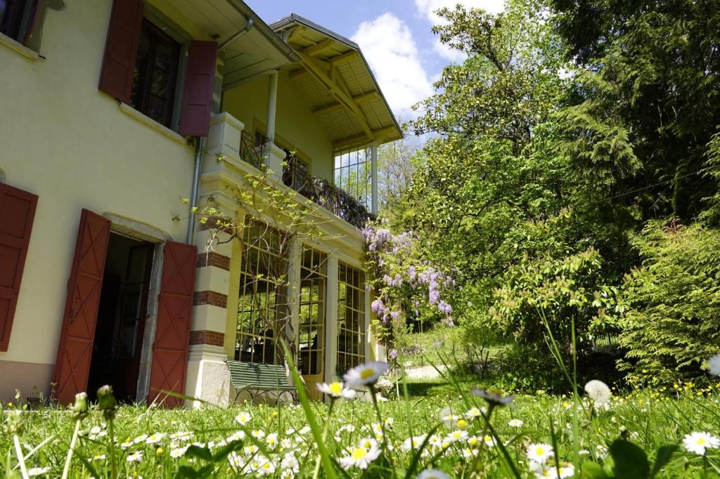 a house with a yard with flowers in front of it at La maison des jours heureux in Leysse