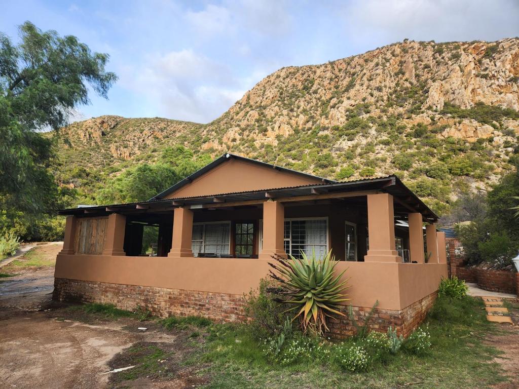 a house with a mountain in the background at Pink Pepper Yard in Uniondale