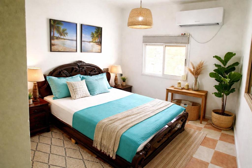 a bedroom with a bed and a potted plant at Cozy Host House with 2 air conditioned rooms in Er Rachidia
