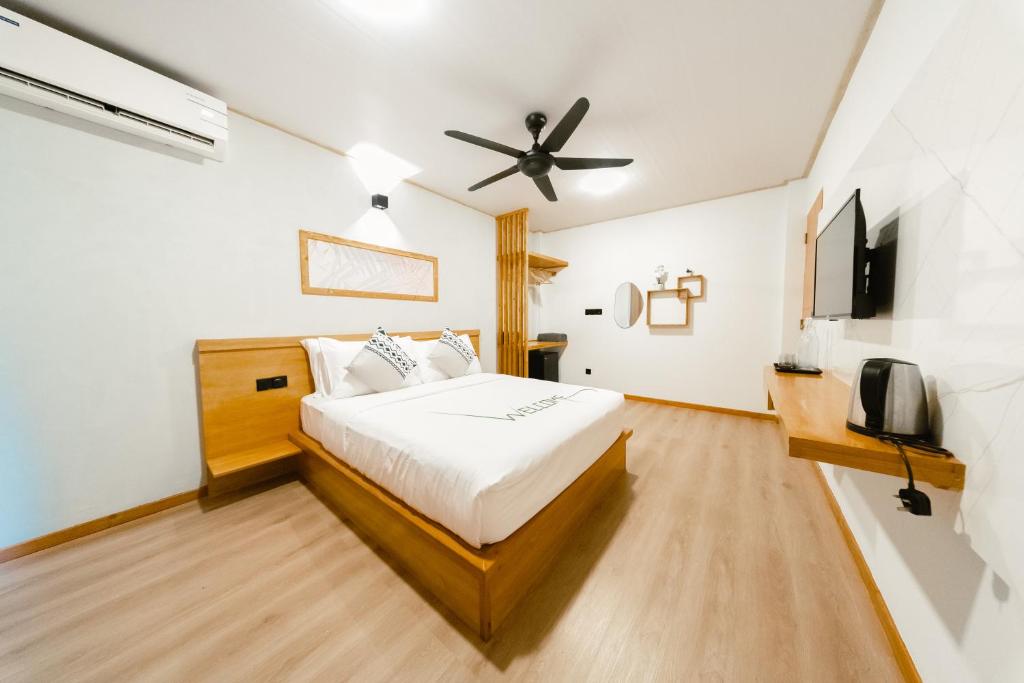 a bedroom with a bed and a ceiling fan at Oasis Retreat Dhiffushi in Dhiffushi