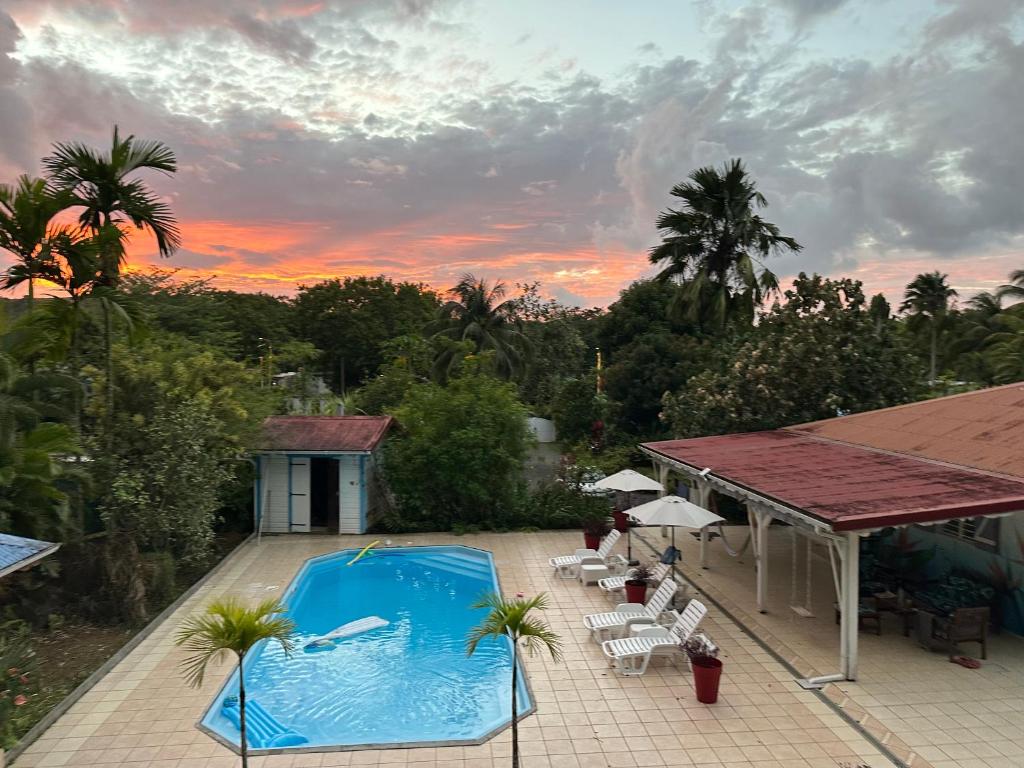 an overhead view of a swimming pool and a house at Le ptit paradis créole in Sainte-Rose