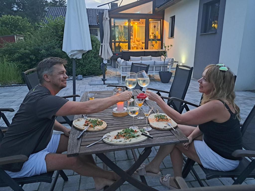 a man and woman sitting at a table with glasses of wine at Beates Daham in Fohnsdorf