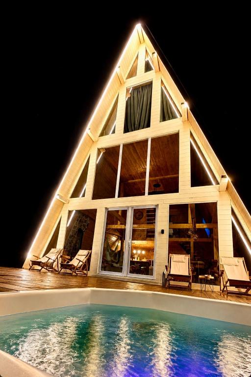 a house with a swimming pool at night at Cabana KayLuna in Mătişeşti