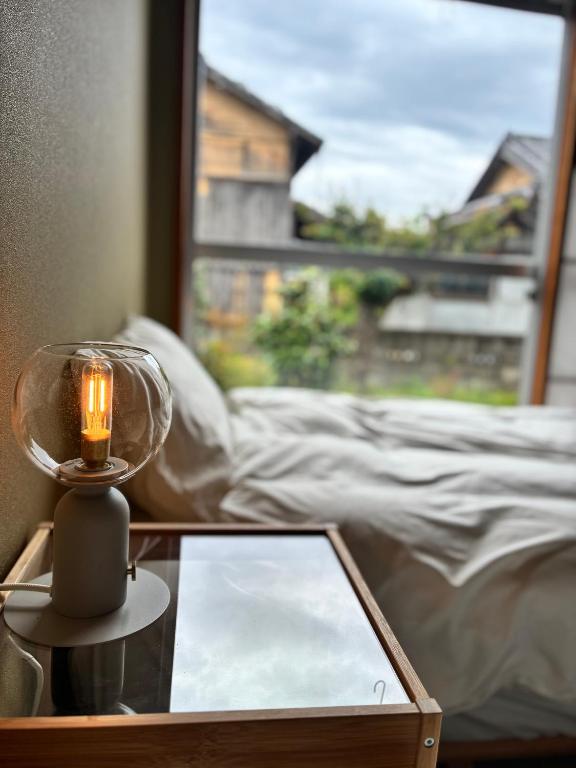 a candle on a glass table in front of a window at Recasa in Imabari