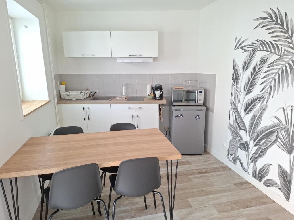 a kitchen with a wooden table and chairs at L'ESPOIRENTHESE T2 35m2 in Nieuil-lʼEspoir