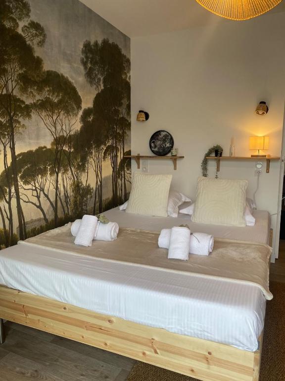 a bedroom with a large bed with white pillows at Charmant Studio in Le Teich