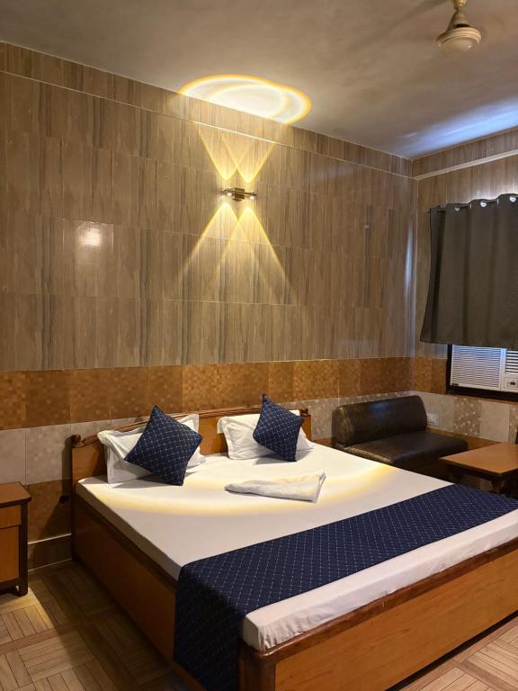 a bedroom with a large bed with blue pillows at Hotel Gangotri in Bahāsi