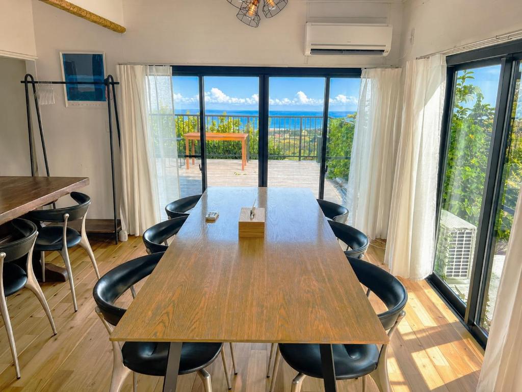 a table and chairs in a room with a large window at Natuur one Kamogawa in Minamiboso