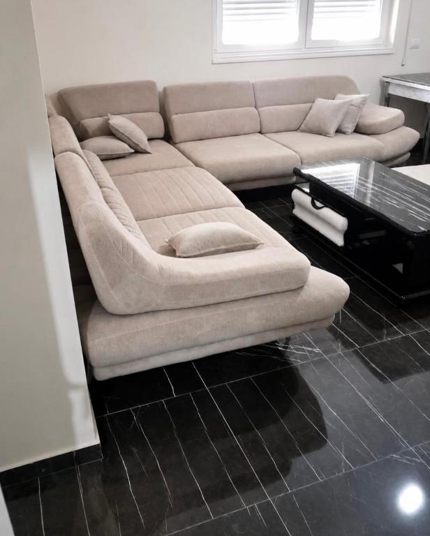 a living room with a couch and a coffee table at Shengjin City Apartment 1 in Skataj