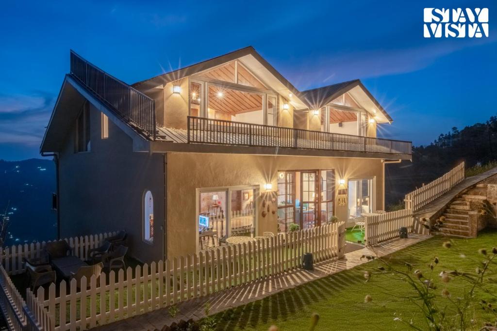 a house with a fence in front of it at StayVista at Ved Vilas in Kīar