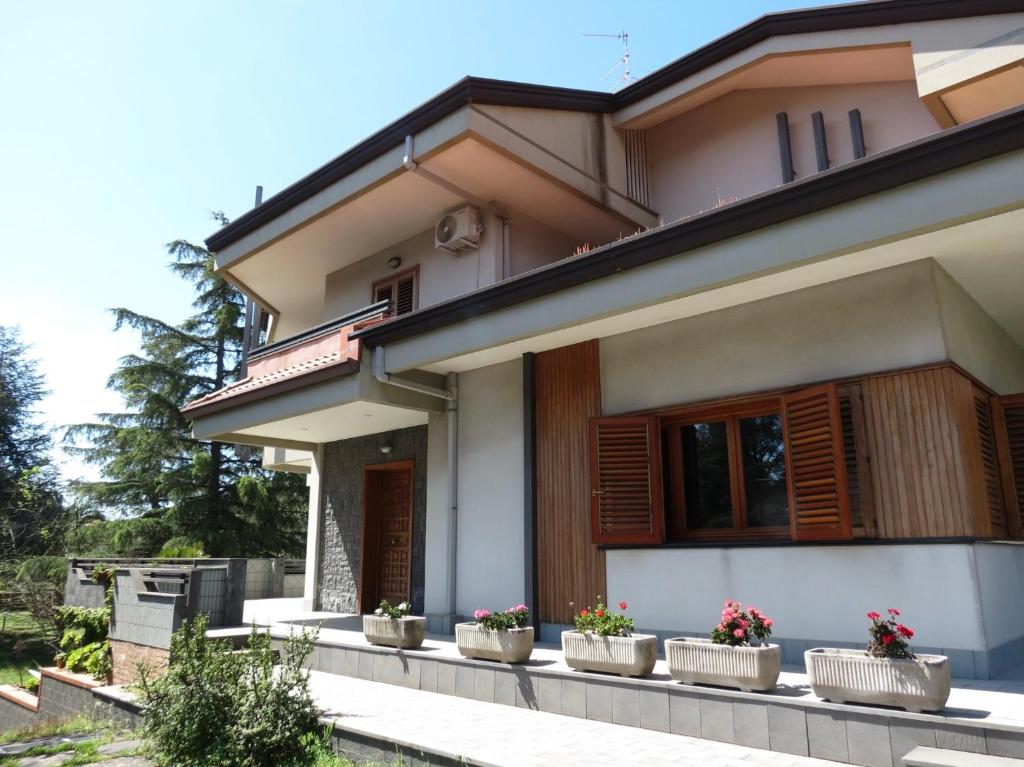 a house with potted plants in front of it at Villa Ara Dell'Etna in Pedara