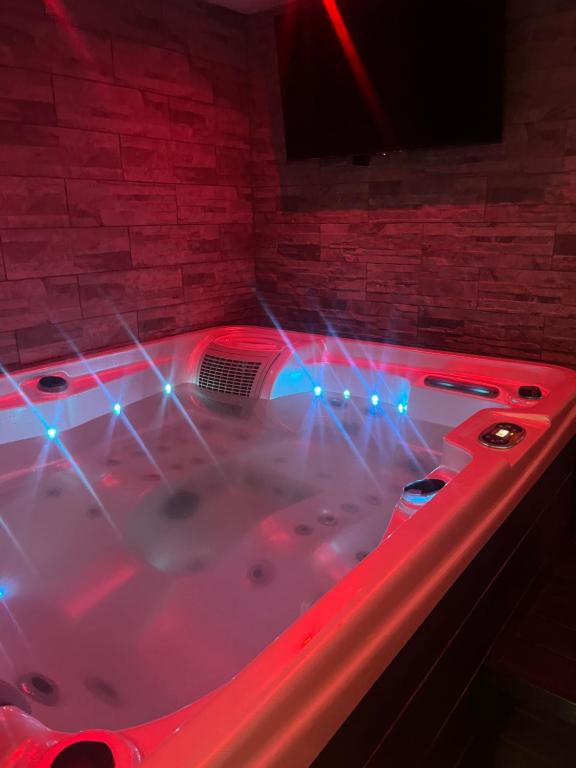 a bathtub with red and blue lights in a room at Le Petit Cocon in Amiens