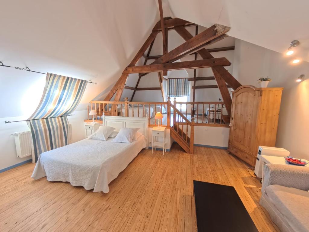 a bedroom with a white bed and a staircase at La Ferme de la Sensée in Gouy-sous-Bellonne